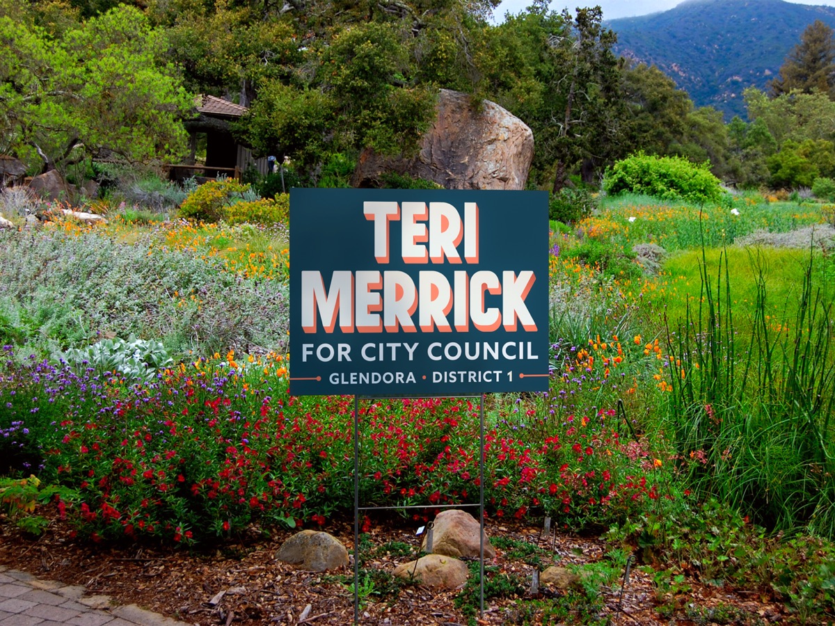 A Teri Merrick for City Council yard sign planted among wildflowers in Glendora